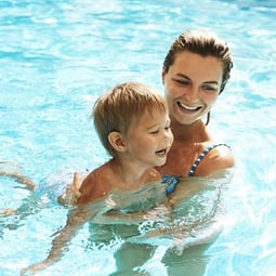 Mutter mit kleinem Kind im Freibad.