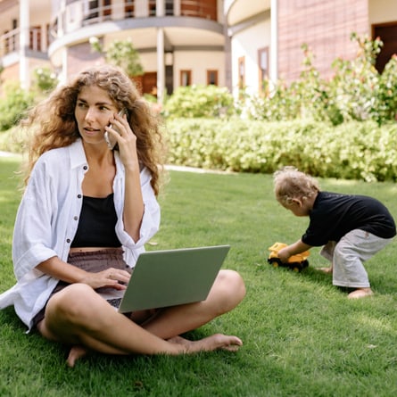 Arbeitende Mutter im Freien mit spielendem Kind Arbeitende Mutter im Freien mit spielendem Kind
