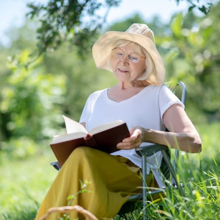 ne ältere Frau liest ein Buch an der frischen Luft Eine ältere Frau liest ein Buch an der frischen Luft