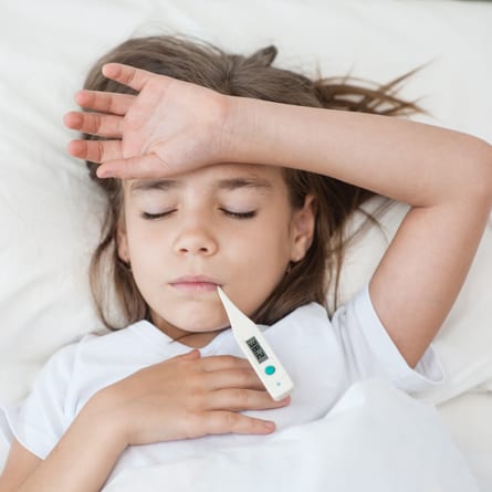 Krankes Kind liegt im Bett mit Fieber Krankes Kind liegt im Bett mit Fieber